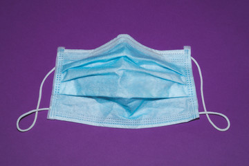 Blue medical mask on violet background. preventive measures against coronavirus and respiratory illness