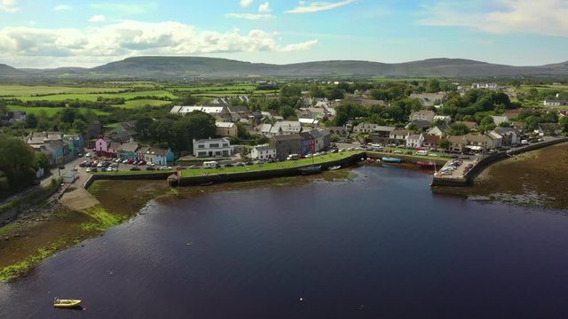 Kinvara, Galway, Ireland, August 2020, Drone pulling backwards away from fishing village and out over water.