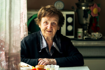 Portrait of senior woman in the kitchen in her village house.