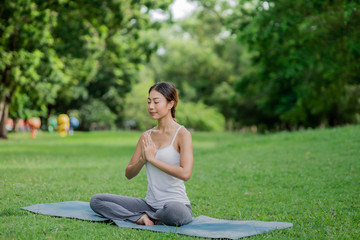 Healthy women doing yoga in the moring at the park . concept healthy and outdoor activity.