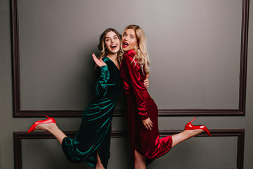 Fashionable girl in long velvet dress expressing sincere emotions. Indoor photo of gorgeous female...