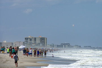 Cocoa Beach, FL, USA - MAY 30, 2020: People on the Cocoa beach in Florida watching SpaceX first astronaut launch from NASA. A SpaceX Falcon 9 rocket.