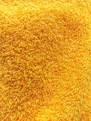 The texture of the terry towel. Yellow background. Towel pattern texture