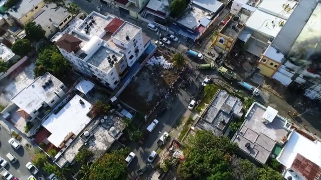 Aerial, drone shot overlooking firetrucks and firefighters, at a burning building, dark smoke rising, in Santo Domingo city, Dominican Republic