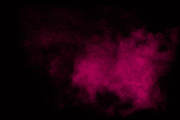 Pink dust particles splash on black background.Pink powder splash.