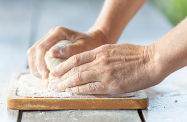 Close up of a woman's hands kneading dough in the early morning