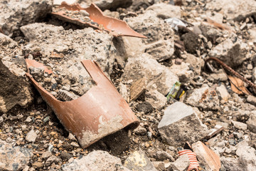 Closeup of shattered PVC pipe and concrete rubble. Can represent demolition or earthquake aftermath.