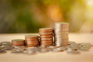 Saving Money concept for Financial, Investment and Business with money coin stack for growing with sunlight bokeh background.