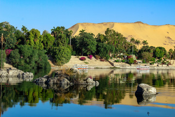 Fototapeta na wymiar Elephantine Island on the bank of Nile River with the blue sky and plants in Aswan, Egypt.