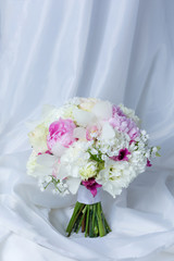 Beautiful wedding bouquet on white fabric background