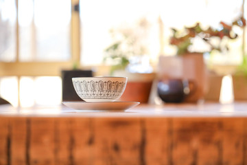 Cup and saucer on display on kitchen table with vibrant window light