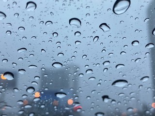 Rain drops on the window. Abstract background. Wet the car window with the background of the night city traffic and traffic congestion concept.