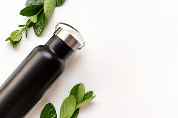 Black thermos with a branch on white background, copy space