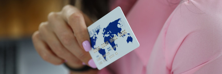 Close-up of tender female hand holding credit bank card. Professional woman employee working with...
