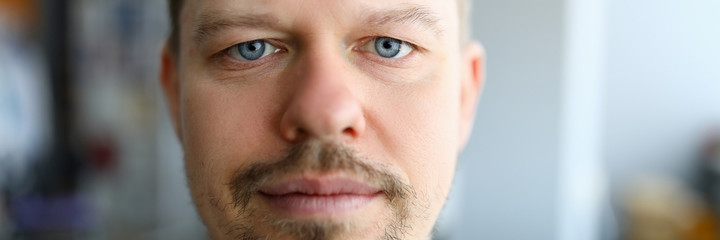 Close-up of serious man taking selfie on smartphone. Macro shot of middle-aged male face. Good-looking person with stubble. Modeling fun and spare time concept
