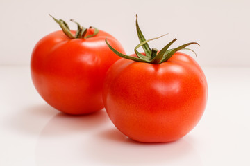 Ripe red tomatoes on a white background.