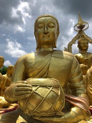 A statue of monks holding monk’s bowl in Makha Bucha Buddhist Memorial Park