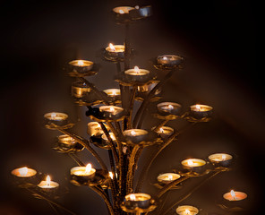 Votive prayer candles burn in a Catholic Cathedral in Rome, Italy.