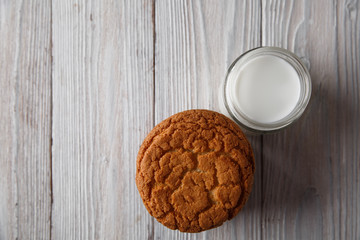 Tasty cookies and a glass of milk in a transparent glass on a rustic white background. Copy space. Flat lay