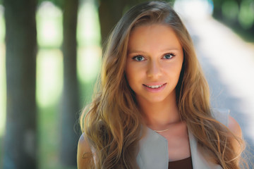 portrait of young smiling attractive caucasian woman in stylish summer outfit in the park