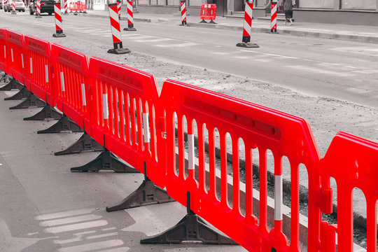 Red temporary fences on the street. Road surface repair.