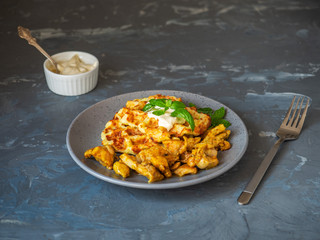Vegetable zucchini waffles with sauce and basil on a gray plate. Gray background