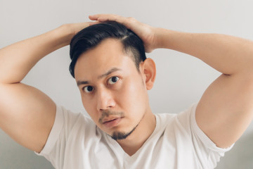 Asian man is checking out his new haircut after covid-19 quarantine.