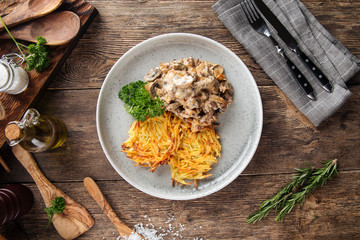Potato pancakes with beef stroganoff on grey plate