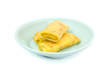 Rolled pancakes on a plate.Pancakes with whipped cream and cottage cheese. White background.