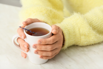 Obraz na płótnie Canvas Woman with cup of hot tea at table, closeup