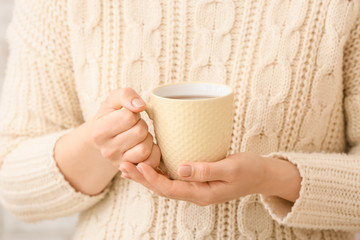 Obraz na płótnie Canvas Woman with cup of hot tea at home, closeup