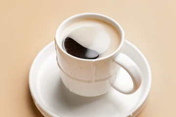 Cup of hot coffee on color background