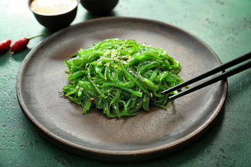 Plate with tasty seaweed salad on table, closeup