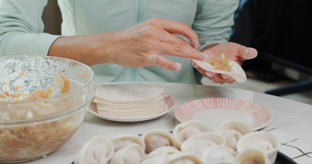 Obraz na płótnie Canvas Woman making meat dumpling at home