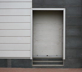 Fototapeta premium Closed metal roller shutter entrance to the modern building