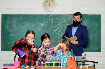 Science is our life. doing experiments with liquids in chemistry lab. chemistry lab. happy children & teacher. back to school. kids in lab coat learning chemistry in school laboratory