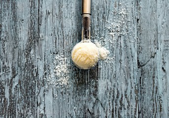 Coconut ice cream ball in an ice cream spoon with coconut shavings on a turquoise old wooden background with space for text. Top view. Flat lay