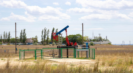 Fototapeta na wymiar Small pump. Oil pump . Equipment for the oil industry. Oil rocking chair in the open air.