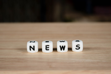 Wooden dice depicting the letters NEWS word concept
