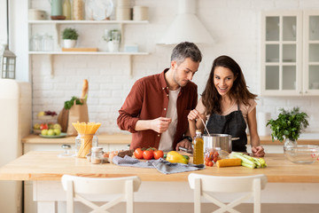 Young couple cooking together at home kitchen
