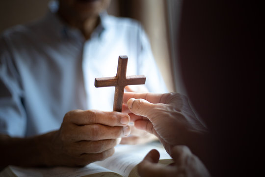 Christian hands of giving cross wood together . Christian good news concept.