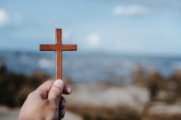 Man holding wooden cross. Concept hope divine pray freedom.