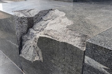 A large pothole in a piece of monolithic black granite at the base of the monument