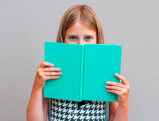 Close up portrait of close cover face behind diary. Girl ready to continue reading isolated on grey background