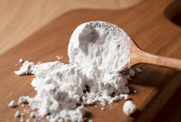 Potato starch and a wooden spoon on the table.