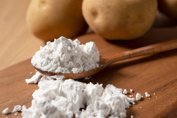 Potatoes and potatoes and a wooden spoon on the table.