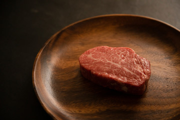Raw meat on the wooden plate
