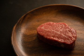 Raw meat on the wooden plate
