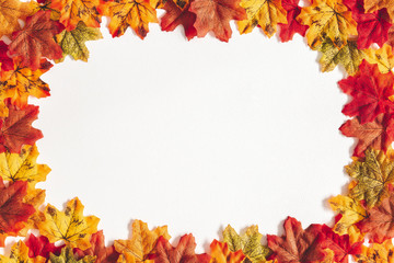 Naklejka na ściany i meble Autumn composition. Frame made of maple leaves on white background. Autumn, fall, thanksgiving day concept. Flat lay, top view