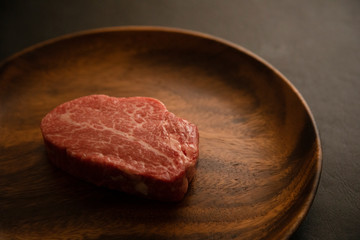 Raw meat on the wooden plate